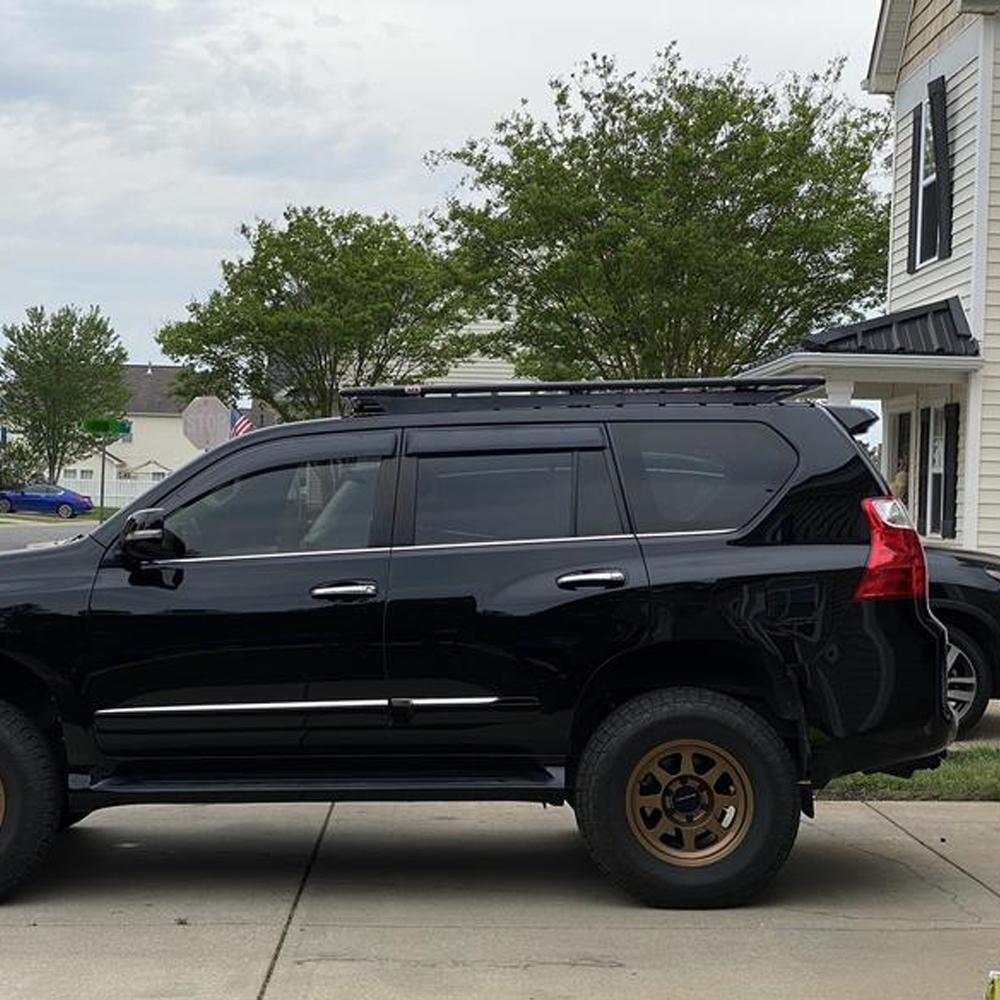 A black ARB Toyota Land Cruiser with high capacity parked in front of a house.