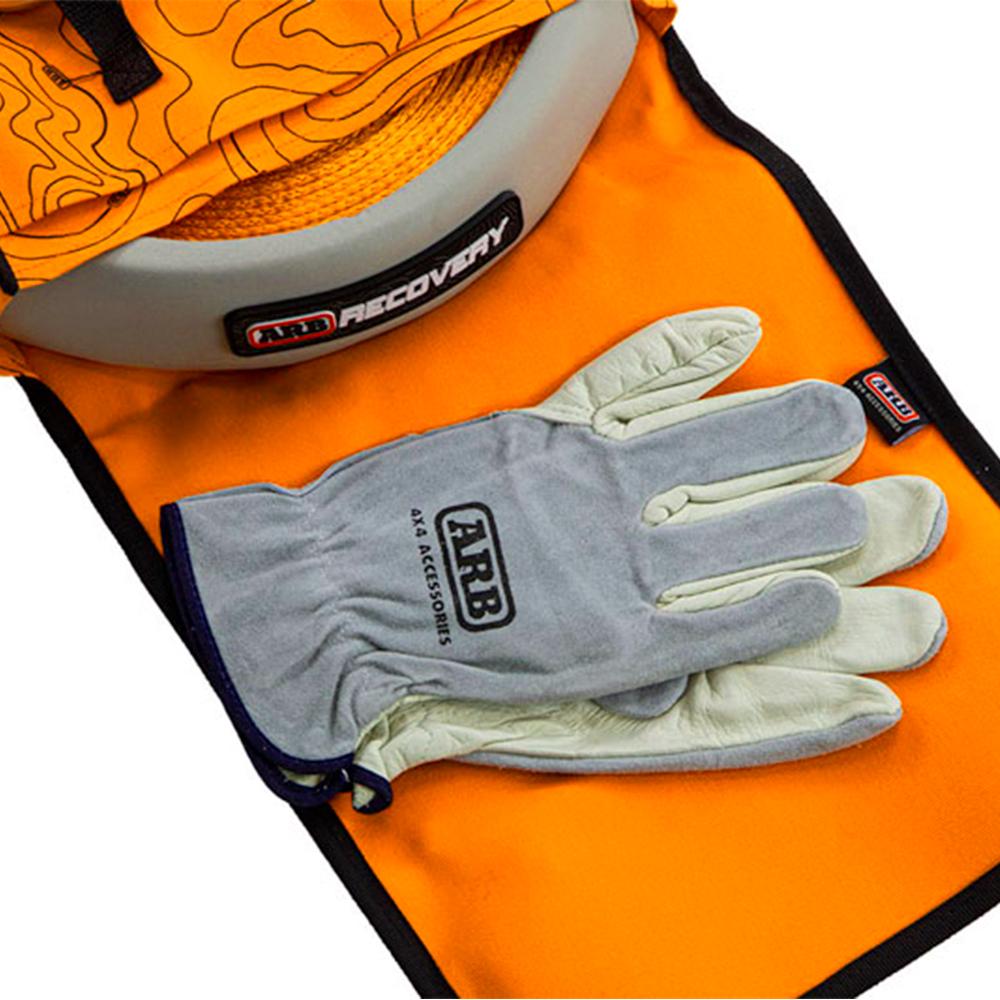 A pair of ARB compact gloves and an ARB waterproof bag on a table.