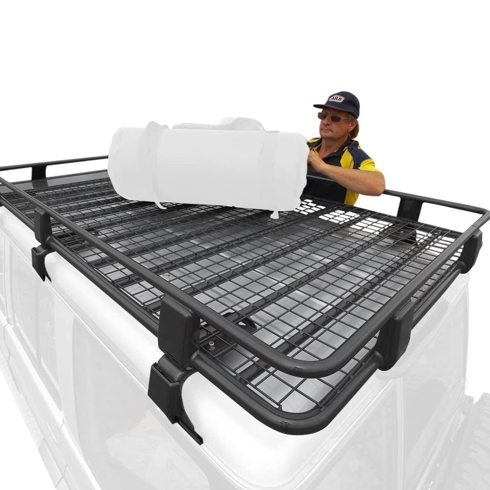 A man is placing a Steel Rack with Mesh Floor Kit 70” X 44” for Toyota 4Runner 2003-2009 ARB 3813010MK4 on the roof racks of a Jeep Wrangler.