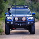 The ARB Under Vehicle Protection Kit 5423010 For Toyota Tacoma (2005-2023) front end of a blue Toyota Tacoma with underbody protection for its 4WD drivetrain.