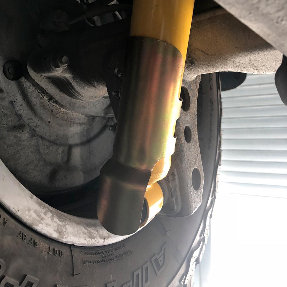 A picture of a vehicle with a yellow brake caliper and Old Man Emu Nitrocharger Sport Shocks replaced with the product and brand name:

A picture of a vehicle with a yellow brake caliper and the OME661 Shock Stone Guard Kit for Toyota Land Cruiser 150 Series, 4Runner, FJCruiser by Old Man Emu.