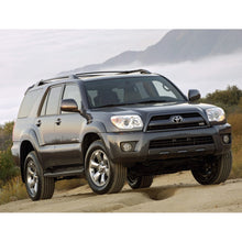 Load image into Gallery viewer, A gray Toyota 4Runner with excellent off-road performance is driving on a dirt road, showcasing its suspension articulation with the KING 2 - 3 inch Lift Kit for 4Runner (03-09) from King Shocks.