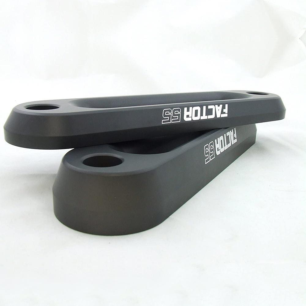 A pair of black Factor 55 sway bars on a white surface.