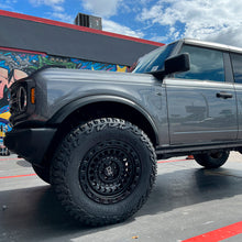 Load image into Gallery viewer, An ARB Panhard Relocation Bracket FK109 for Ford Bronco (21-ON) truck is parked in front of a graffiti wall. (Brand Name: Old Man Emu)