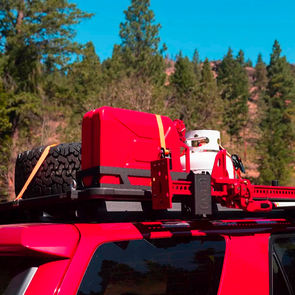 A red jeep with an ARB Base Rack Mount Kit (Black) For Toyota 4Runner (2010-2022) ARB 17921030 on top of it.
