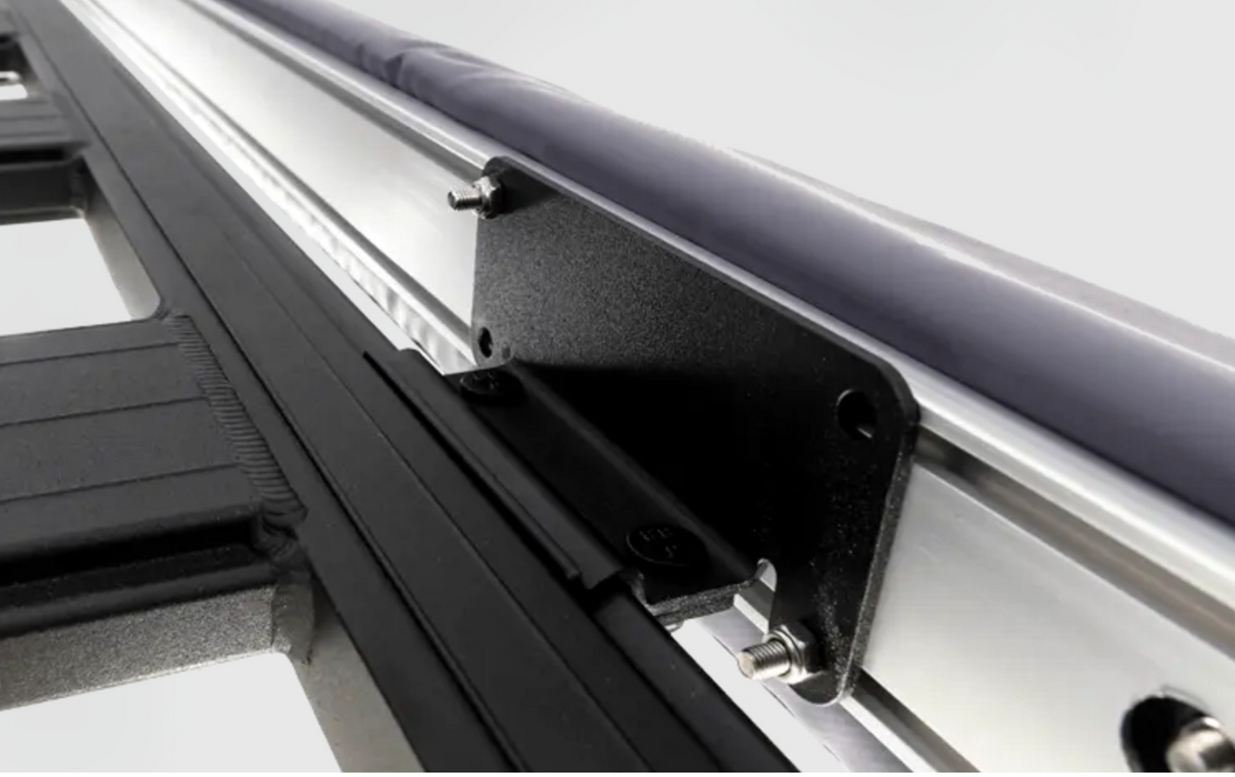 A close up of a metal rail with an ARB BASE Rack Awning Bracket 1780240 attached to a vehicle.