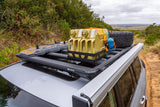 A Land Rover with an ARB BASE Rack Awning Bracket 1780240 by ARB and a roof rack on top of it.