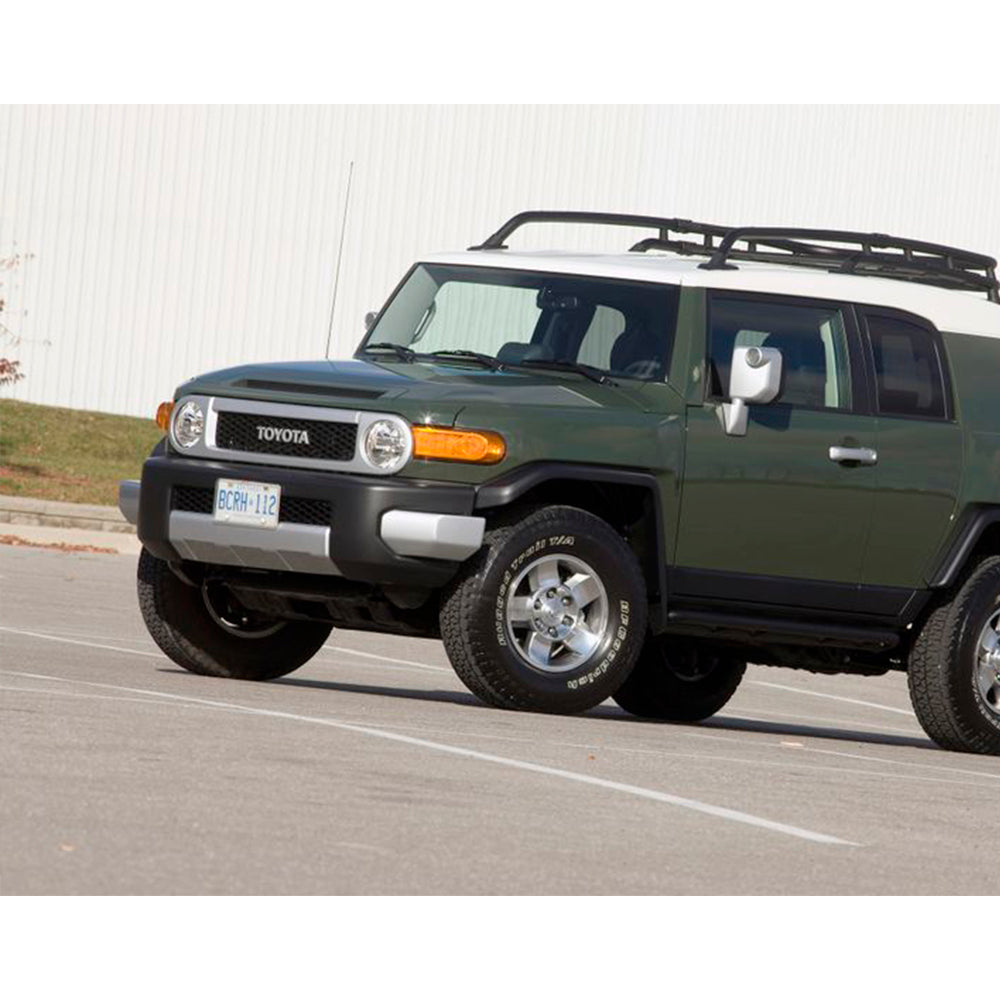 A green SUV with an ARB Base Rack Mount Kit (Black) For Toyota FJ Cruiser (2007-2016) ARB 17920020 parked in a parking lot.