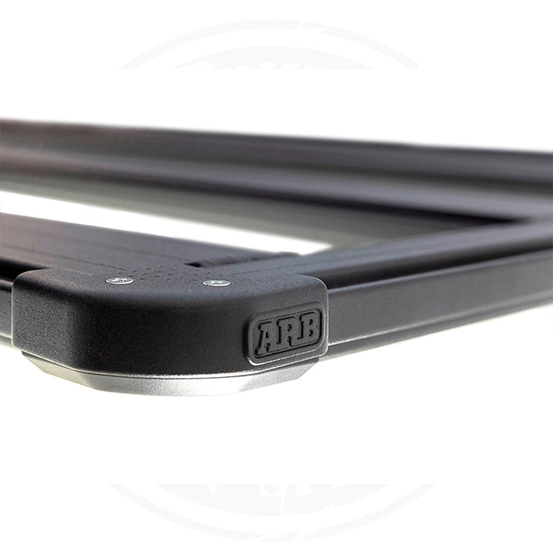 A black Base Rack For Toyota FJ Cruiser 2007-2016 ARB 1770040 with mount brackets on a white background.