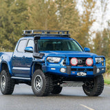 A blue ARB Toyota Tacoma with high capacity is driving down the road.
