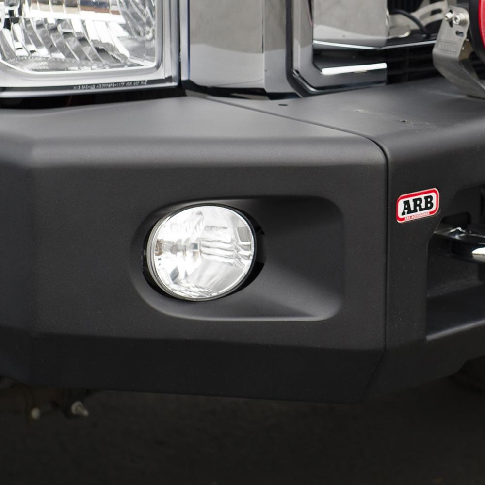 A close up of the front bumper of a black truck with winch compatibility and LED indicators, featuring the Kit Textured Modularbar Type A for FORD F-250 SUPER DUTY (2011 - 2016) by ARB.