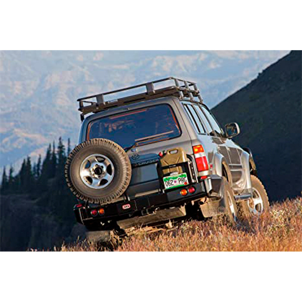 An ARB Modular Rear Bumper 5611210 for Toyota LandCruiser 80 Series (1990-1997) is driving down a hill in the mountains.