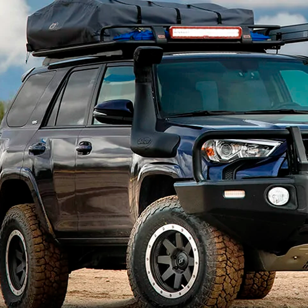 The ARB Touring Roof Rack FJ Cruiser (2007-2009) 3800200KLC2, known for its high quality materials, is parked in the desert.