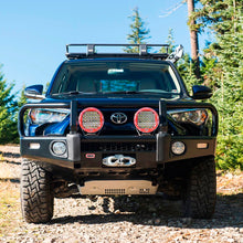 Load image into Gallery viewer, A black ARB 17921030 Toyota 4Runner with a Base Rack Mount Kit (Black) For Toyota 4Runner (2010-2022) is parked on a dirt road.