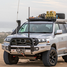 Load image into Gallery viewer, A silver ARB Toyota Land Cruiser with an Alloy Flat Rack With Mesh Floor for Toyota Land Cruiser 200 Series ARB 4900040MKLC2 is parked in the sand, providing maximum protection and displaying an impressive approach angle.