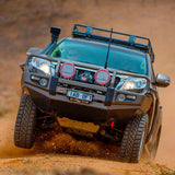 The Roof Rack Fitting Kit for Land Rover Discovery HT3 year 1998 ARB 3700080, equipped with a fitting kit, is driving down a dirt road.