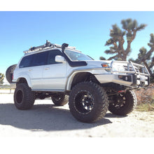 Load image into Gallery viewer, A white Toyota Land Cruiser with adjustable damping and Old Man Emu BP-51 shock absorbers is parked in the desert, showcasing its off-road performance.