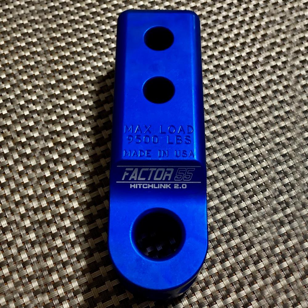A Factor 55 HitchLink 2.0 00020-02 made in USA blue metal bracket with holes, designed for 9500LB capacity and compatible with aluminum hitchlink.