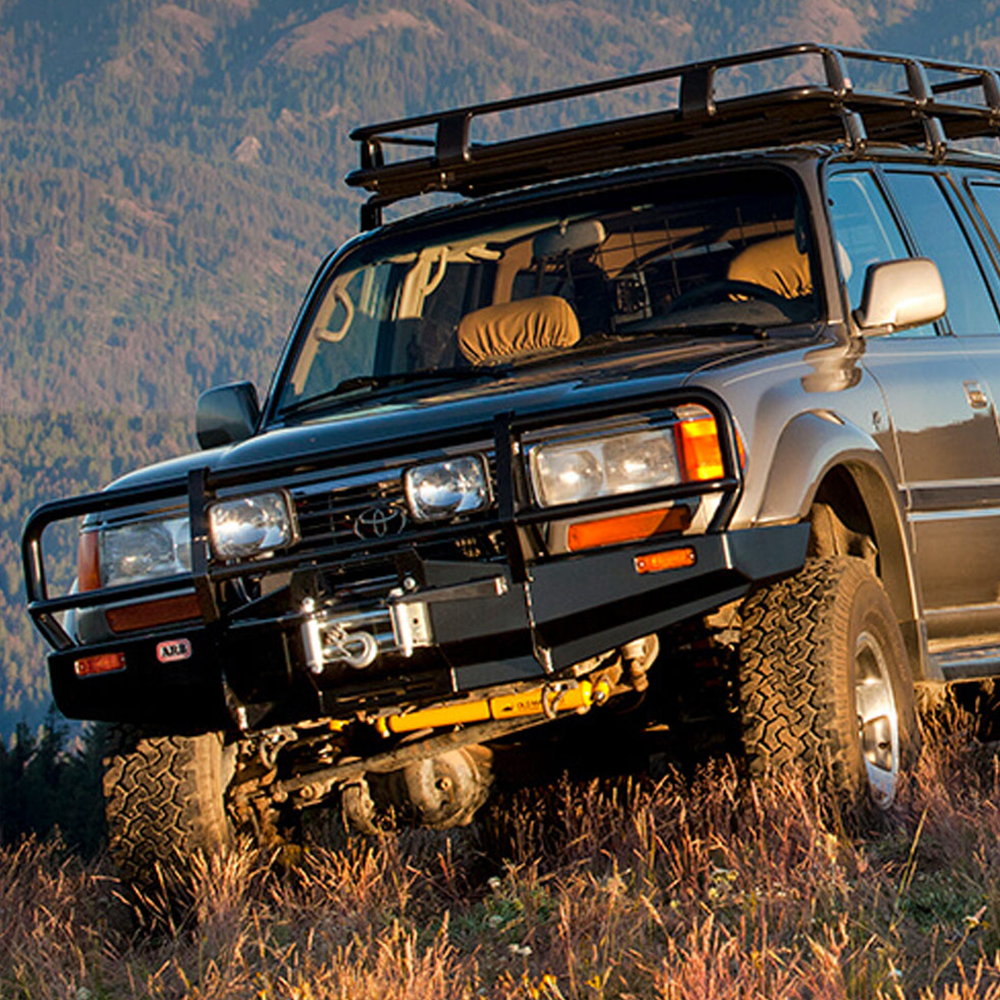 An Old Man Emu Toyota Land Cruiser with increased ride height parked in a field.