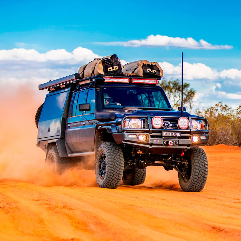 A high-quality Old Man Emu Rear Nitrocharger Sport 60081 for Prado 150 Series LWB (Coil Spring Models Only), powered Toyota Land Cruiser, conquering the desert terrain with its heavy gauge reserve tube.