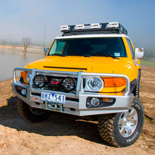 Load image into Gallery viewer, A yellow Toyota FJ Cruiser equipped with the Deluxe Winch Front Bumper With Bull Bar for Toyota FJ Cruiser 2007-2016 by ARB.
