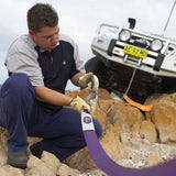 A man using an ARB Winch Extension Strap ARB725LB to work on a vehicle.