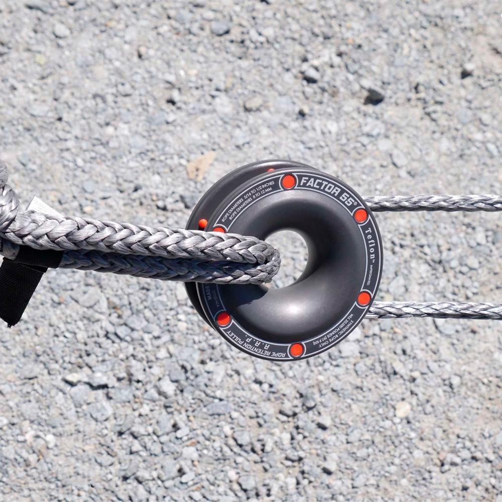 A Factor 55 Rope Retention Pulley Snatch Block 00260 with a donut attached to it, suspended by a soft shackle.