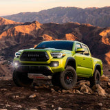 The 2020 Old Man Emu Toyota Tacoma, known for its longevity and ride comfort, is parked on a rocky hillside.