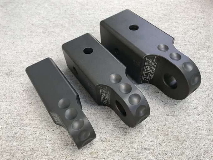 Three high quality black Factor 55 HITCHLINK 3.0 in Gray 00027-06 brackets on a concrete floor compatible with HitchLink and hitch receiver.