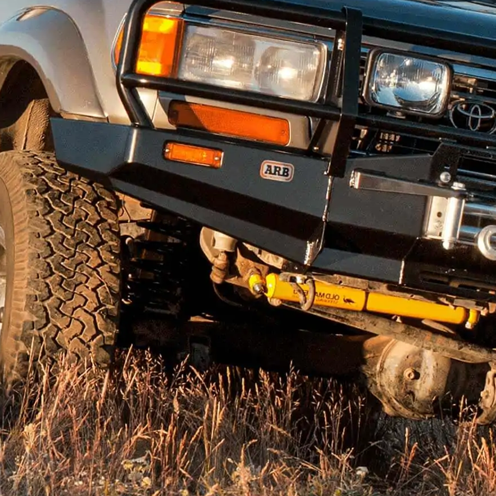 An ARB Old Man Emu Front Coil Springs 2419 for Toyota Landcruiser 80 and 105 Series (3.5 inch LIFT - Constant Load 110.231 LB), featuring easy installation and oxidation protection, is parked in a field.