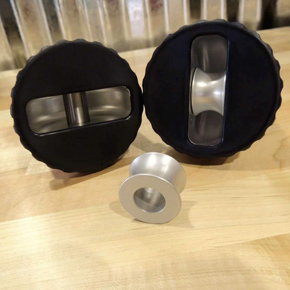 A pair of Factor 55 stainless steel coffee stirrers on a wooden table, providing corrosion protection.