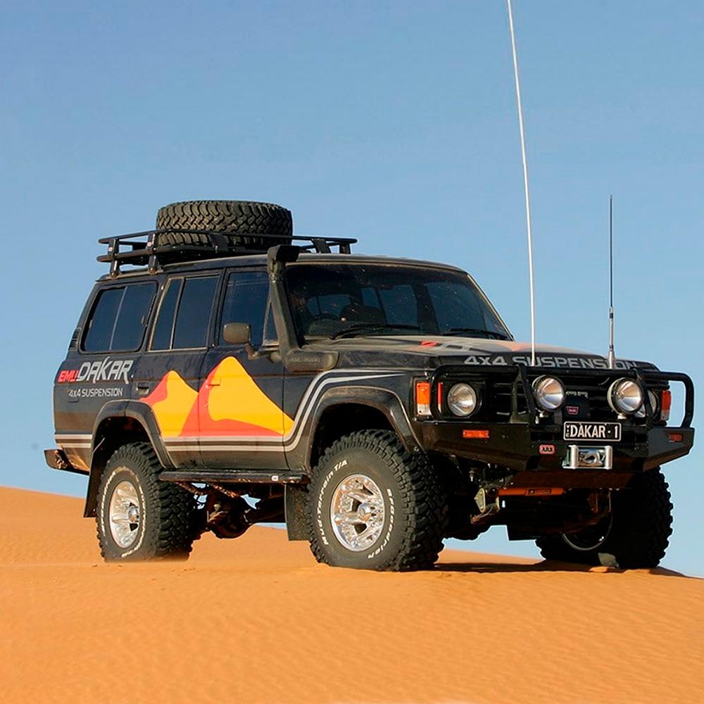A high capacity jeep is parked on a sand dune in the desert, equipped with a Roof Rack Fitting Kit 43” x 49” for Toyota Land Cruiser 1980 - 1990 ARB 3700040.
