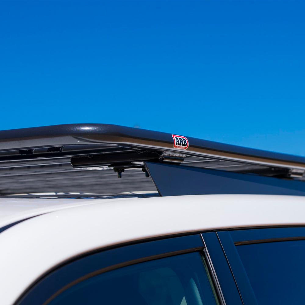 An ARB Steel Roof Rack for All Jeep CHEROKEE XJ 3800030K, providing secure storage and featuring a drainage channel.