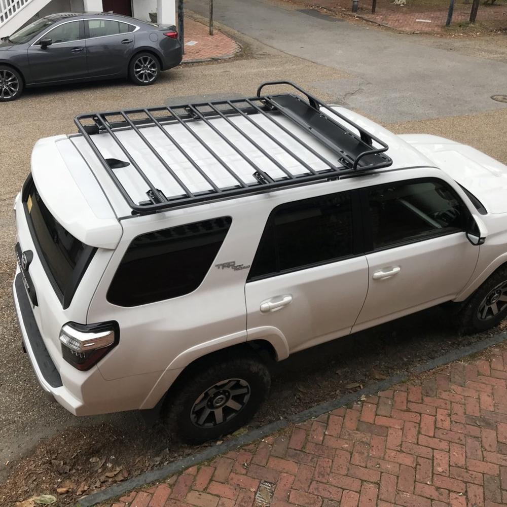 A white ARB Toyota 4Runner equipped with a ARB Touring Roof Racks 3813200KJK featuring crossbars for increased carrying capacity.