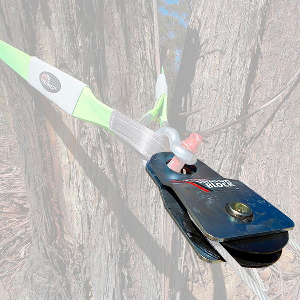 A green ARB Snatch Block 7000 - 30,000lb Breaking Strength ARB2091A attached to the side of a tree, featuring a carrying capacity for wind noise reduction.