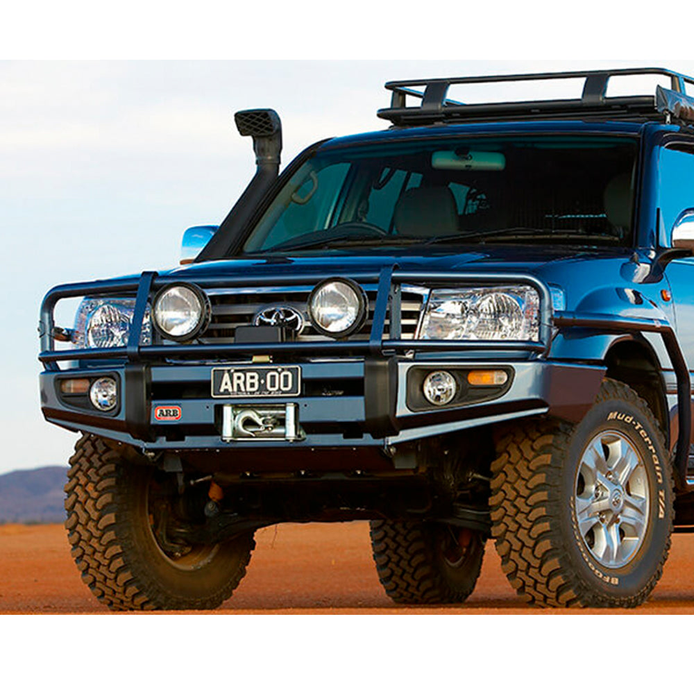 A blue Old Man Emu Toyota Land Cruiser with exceptional suspension performance is parked in the desert.