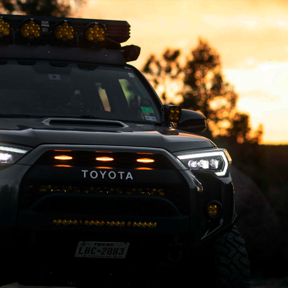 The Morimoto XB LED headlights for Toyota 4Runner (2014-2023) enhance the front end of a Toyota 4Runner at sunset, making it stand out as a stylish and eye-catching aftermarket modification.