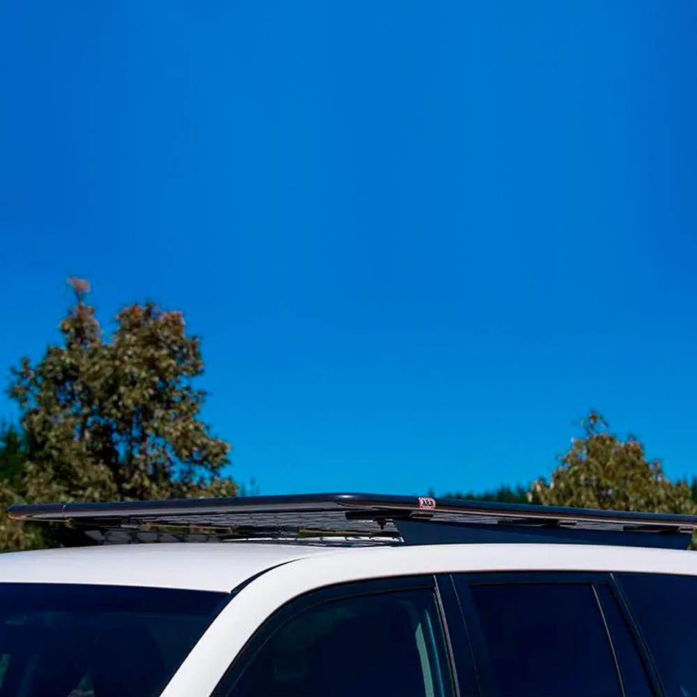 A secure white SUV with an ARB Steel Roof Rack on top, perfect for fitting kits or drainage channels.