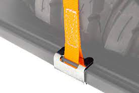 An ARB Rack Spare Wheel Y Strap 1780380 is securely attached to the back of a car using tie-down points for cargo loading purposes.