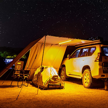 Load image into Gallery viewer, A waterproof SUV is parked under an ARB Touring Awning with Light 814409 at night.