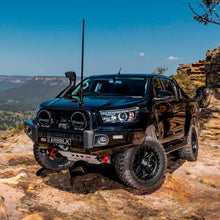 Load image into Gallery viewer, A black Old Man Emu Toyota Hilux parked on a rocky cliff, utilizing the ARB Old Man Emu Rear Nitrocharger Sport 60086 for Toyota Prado 150 Series SWB (Coil Spring Models Only) for optimal performance.