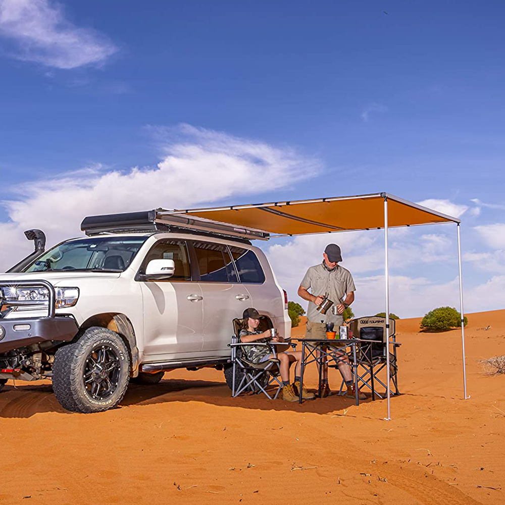 A Toyota Land Cruiser equipped with ARB roof racks and an ARB Touring Awning with Light 814409, perfect for camping in the waterproof tent in the desert.