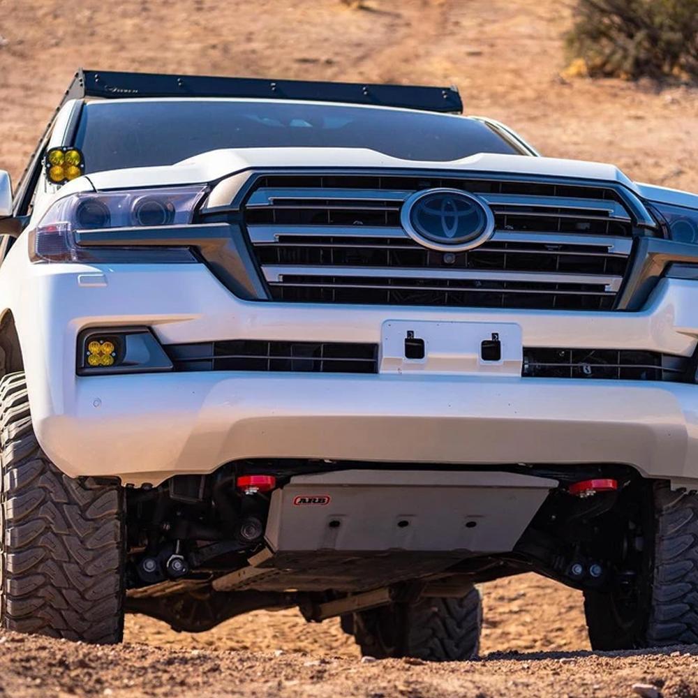 A white ARB Toyota Land Cruiser with high visibility on a dirt road.