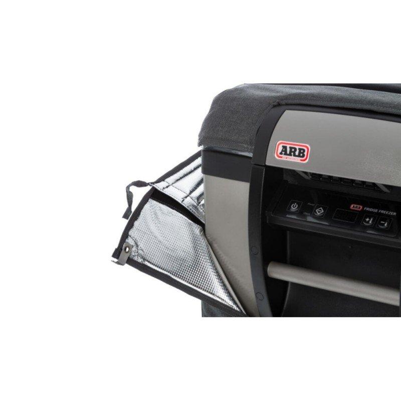 A car with an ARB Transit Bag for Classic Series II - 50 QT Fridge Freezer covering its ARB Fridge Freezer, and an ARB door open.