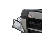 A car with an ARB Transit Bag for Classic Series II - 50 QT Fridge Freezer covering its ARB Fridge Freezer, and an ARB door open.