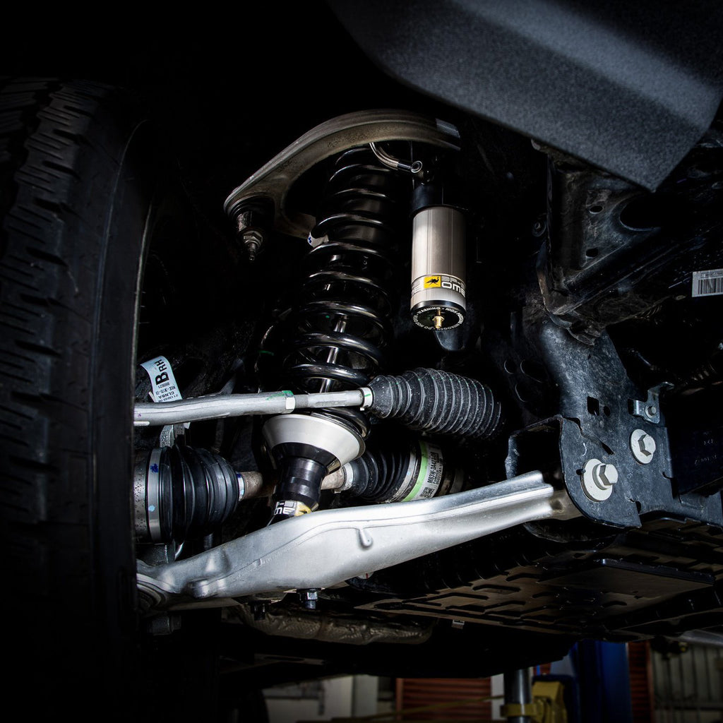 A close up of the suspension system of a car highlighting the Old Man Emu BP-51 shock absorbers.