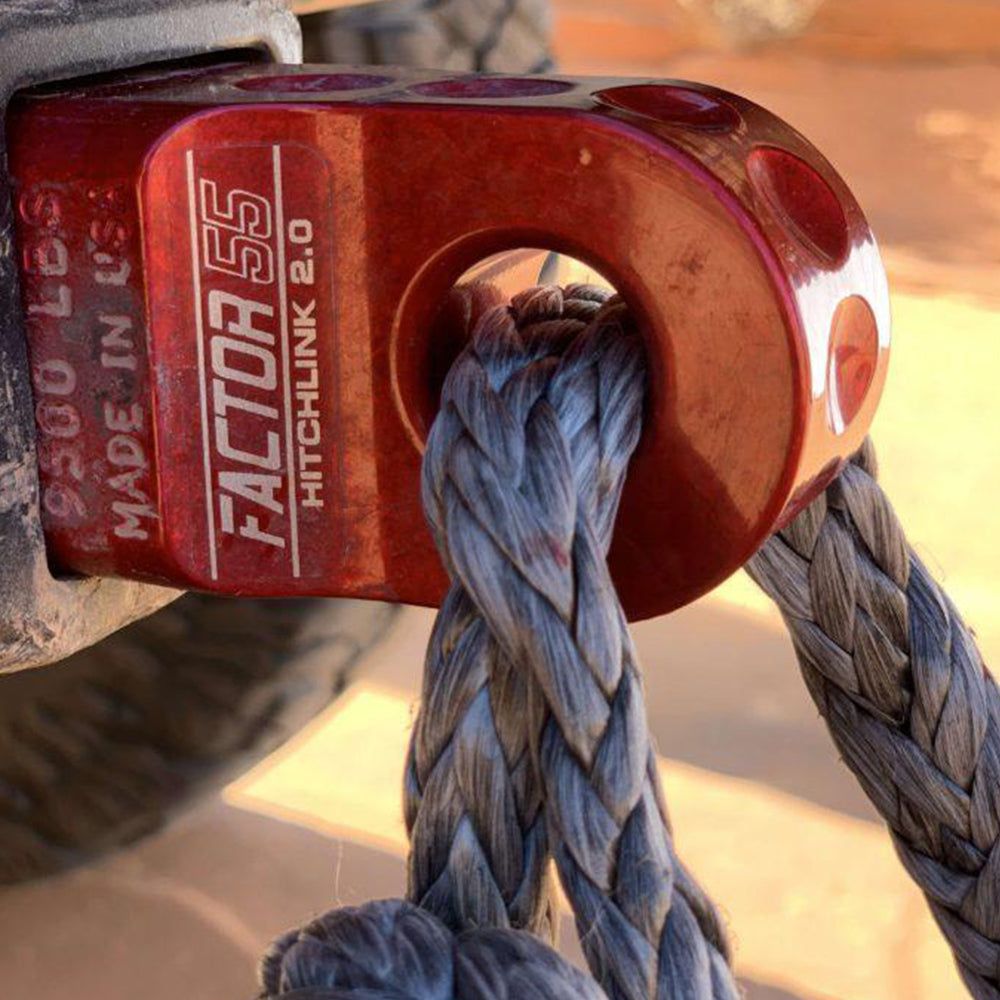 A red rope is attached to the back of a jeep using a Factor 55 HitchLink 2.0in Red 00020-01.