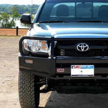 Load image into Gallery viewer, The front end of a durable ARB Deluxe Winch Front Bumper 3423030 for Toyota Tacoma 2005 - 2011, featuring steel construction and a multi-fold upswept design.