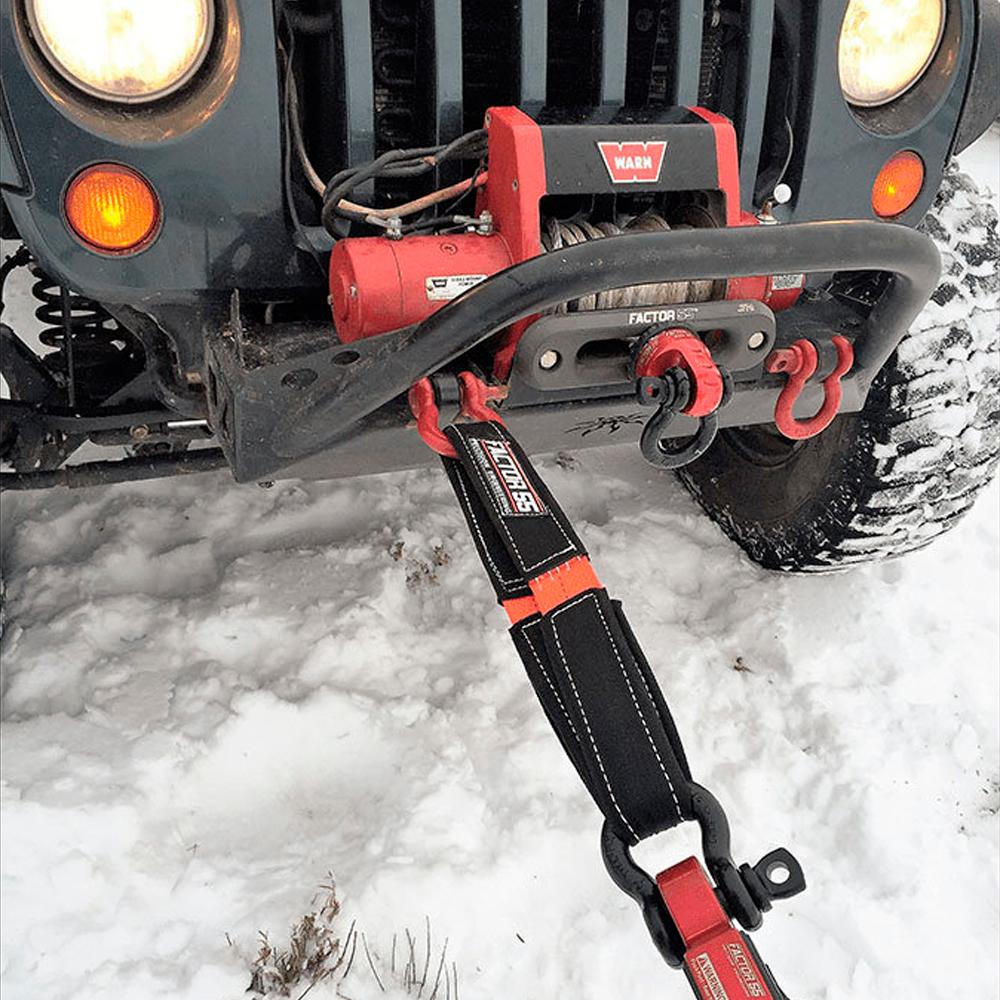 A jeep equipped with a Factor 55 Shorty Strap II 00078, perfect for recovery situations.