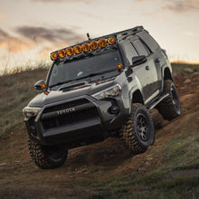 Load image into Gallery viewer, The Old Man Emu 4Runner, equipped with adjustable damping and OME BP-51 shock absorbers, is delivering exceptional off-road performance as it navigates a rugged dirt road.